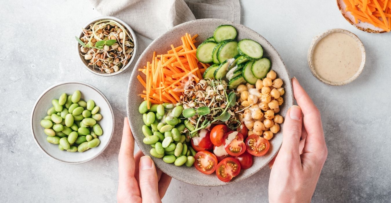 Un diététicien qui tient une assiette avec des légumes crus 