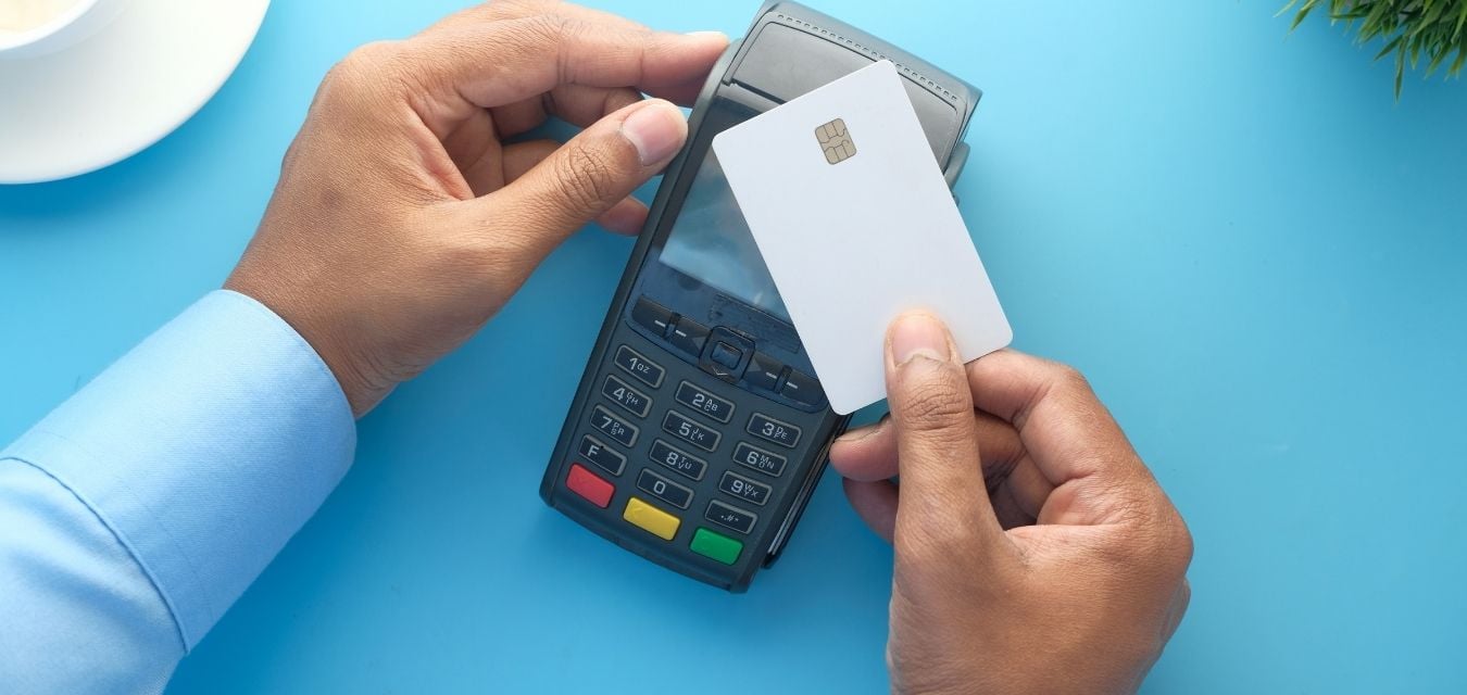 Une personne qui paye avec sa carte bancaire blanche sur un TPE acheté auprès d'une banque pro