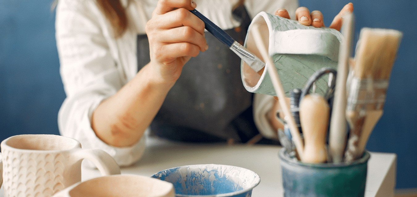 Une artisane en micro-bic, qui peint une tasse en céramique 
