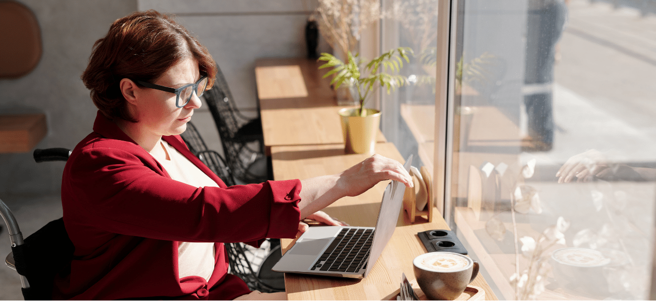 calcul charges salaire net brut auto-entrepreneur, femme handicapée qui travail dans un café sur son ordinateur