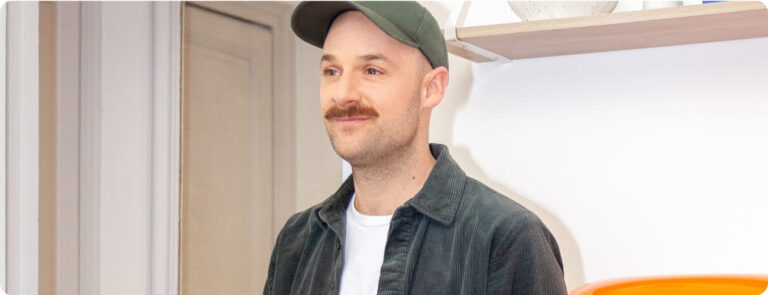 Un entrepreneur avec une casquette très heureux de tenir sa comptabilité en ligne grâce à un logciel de comptabilité tel qu'Indy