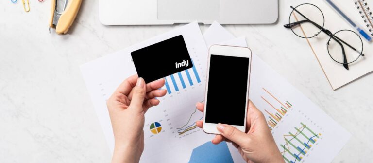 personne tenant dans la main un téléphone et une carte bancaire indy afin de faire un virement