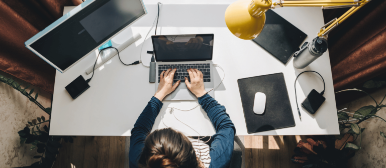 un freelance travaille sur ordinateur sur un bureau vu de haut