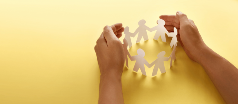 protection sociale, mains entourant des petits bonshommes en papier sur fond jaune