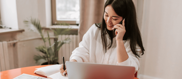 femme souriante qui fait sa comptabilité en ligne