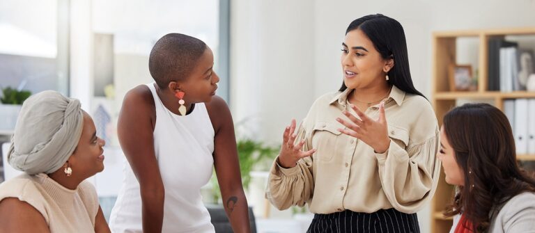 Femmes entrepreneuses discutant autour d'une table dans un bureau moderne et lumineux