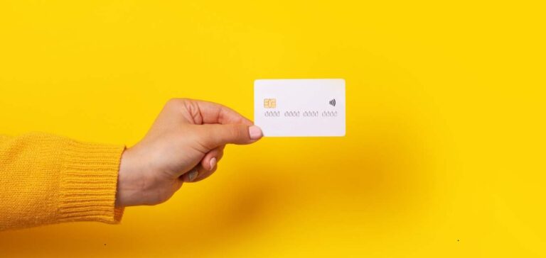 main qui présente une carte bancaire professionnelle sur fond jaune